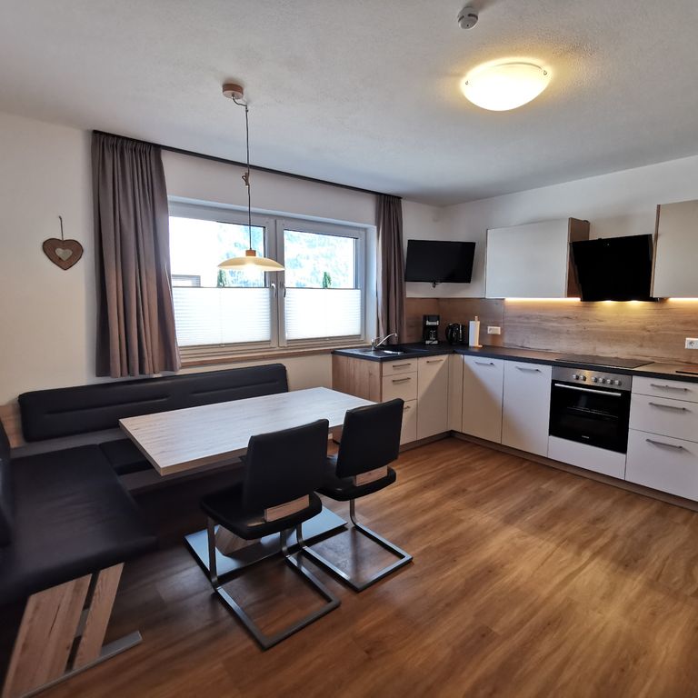 Moderne, voll ausgestattete Wohnküche mit Esstisch in der Ferienwohnung SunAlpin im Zillertal